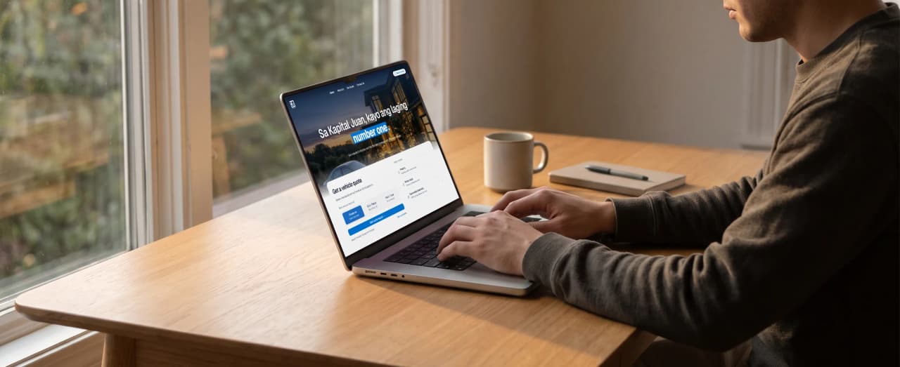 Someone at a desk by a window, working on Kapital Juan Insurance's site on a laptop